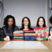 A cross-section of judges seated behind a pile of books.